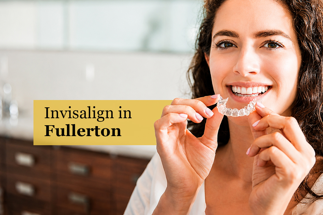 Smiling woman holding a clear aligner tray