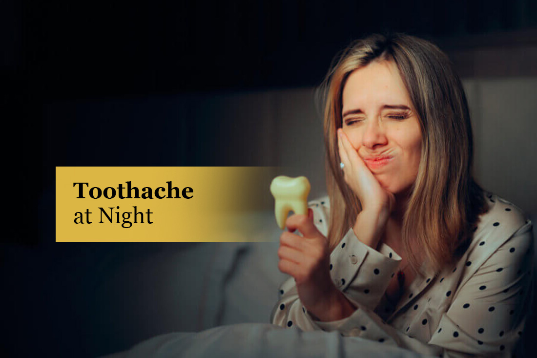 Toothache at Night: woman in pajamas holding her cheek in pain while holding a tooth model
